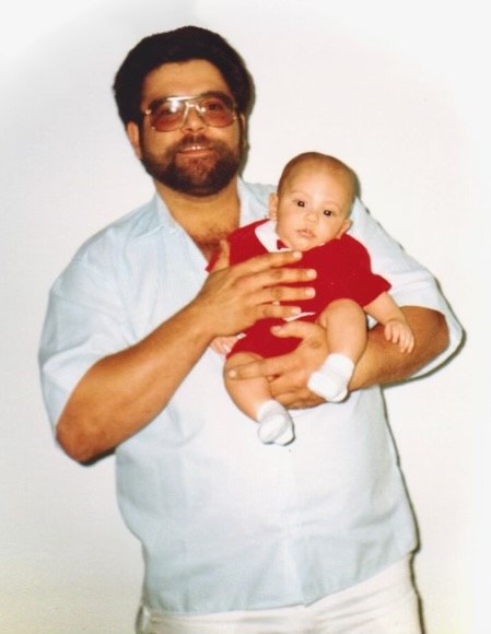 A young Mick as a baby, held by his father.